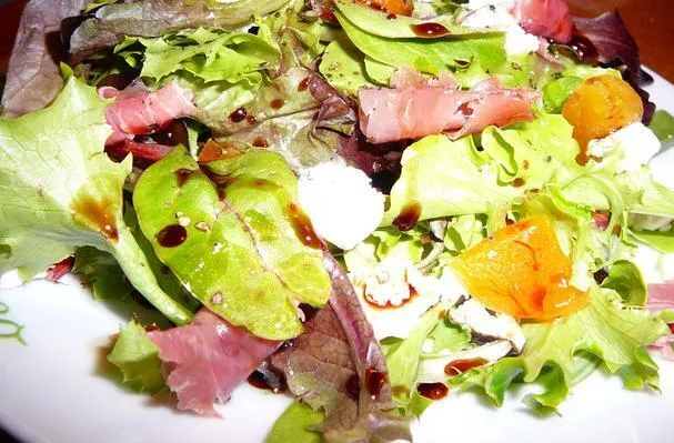 Mesclunmix med getost, aprikoser, prosciutto och vino cotto